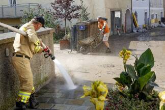 Wasser marsch – die Feuerwehr säubert die schlammbedeckten Straßen und Gassen der Halleiner Innenstadt. 