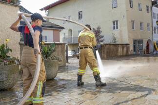 Wasser marsch – die Feuerwehr säubert die schlammbedeckten Straßen und Gassen der Halleiner Innenstadt. 