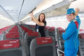 Bevor die Passagiere einsteigen, müssen die Gepäckfächer geöffnet werden, erklärt Kabinenchefin Elisabeth Spiegelsberger. Die SN-Redakteurin darf mithelfen.   Bevor die Passagiere einsteigen, müssen die Gepäckfächer geöffnet werden, erklärt Kabinenchefin Elisabeth Spiegelsberger. Die SN-Redakteurin darf mithelfen.