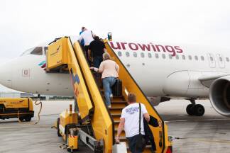 Bevor die Passagiere einsteigen, müssen die Gepäckfächer geöffnet werden, erklärt Kabinenchefin Elisabeth Spiegelsberger. Die SN-Redakteurin darf mithelfen.   Bevor die Passagiere einsteigen, müssen die Gepäckfächer geöffnet werden, erklärt Kabinenchefin Elisabeth Spiegelsberger. Die SN-Redakteurin darf mithelfen.
