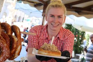 Johanna Leitner am „Salzburger Spezialitäten“-Stand mit einem frischen Bauernkrapfen mit Sauerkraut um fünf Euro.  
