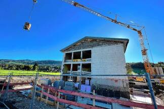 In unmittelbarer Nachbarschaft der Containerschule wird das alte Schulgebäude ausgehöhlt und mit einem Neubau „ummantelt“. 