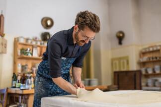 Burgherr Erasmus Almásy beim Ziehen des Strudelteigs. Burgherr Erasmus Almásy beim Ziehen des Strudelteigs.