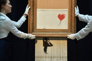 Das geschredderte Banksy-Bild des Mädchens mit dem Ballon löste großes Aufsehen in der Kunstwelt aus. Es heißt nun „Love is in the bin“ – Liebe ist im Eimer.  