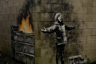 Nein, der Bub auf dem Bild freut sich nicht über Schnee, er steht im Ascheregen – so sieht es Banksy.  