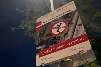 Das Schild hängt an einem Lichtmast. 