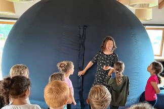 In dem fünf Meter breiten und drei Meter hohen aufblasbaren Zelt reist Astronomin Ruth Grützbauch jeweils mit einer Klasse mittels Videoprojektionen durch das Universum.  