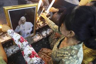 In Yogyakarta, Indonesien, zünden Gläubige in einer Kirche Kerzen für den Papst an. In Yogyakarta, Indonesien, zünden Gläubige in einer Kirche Kerzen für den Papst an.