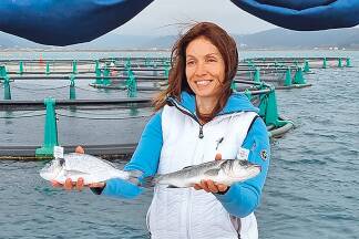 Irena Fonda mit einer Dorade und einem Wolfsbarsch aus ihrer Aquakultur.  