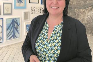 Judith Legat in der Galerie L.art. Hinter ihr ist als Wand ein Teil der historischen Salzburger Stadtmauer zu sehen.  