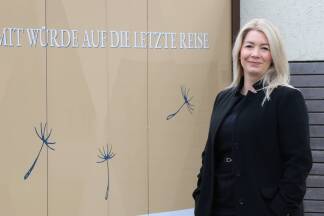 Verena Wengler vor dem Einfahrtstor zur Bestattung Salzburg in Gneis 