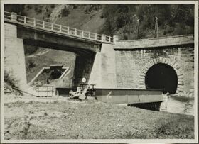 1928, nahe Salzach, Straßenbrücke und Eisenbahnbrücke über den Trattenbach, Tunnelmündungen der beiden Einspuren; Kabelverlegung durch Fa. Ing. A. Spritzer, Aktiengesellschaft für Bauwesen.